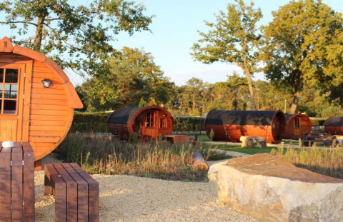 Alojamiento glamping en cabañas de madera con forma de barril en Campingpark Heidewald rodeado de naturaleza.