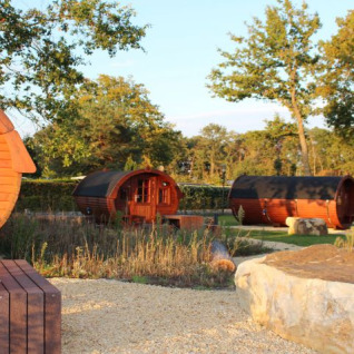 Glamping-Unterkünfte in weinfassförmigen Holzhütten bei Campingpark Heidewald im Grünen in Deutschland.