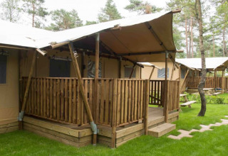 Glampingaccommodatie op Campingpark Heidewald Duitsland met houten veranda’s en groene omgeving.