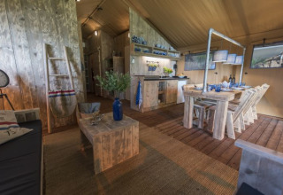 Glampingindkvartering med rustik træindretning og spiseplads på Campingpark Heidewald i Tyskland.