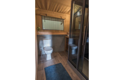 Baño moderno con inodoro y ducha en alojamiento glamping en Campingpark Heidewald, Alemania.