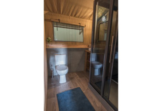 Modern bathroom with toilet and shower in a glamping lodge at Campingpark Heidewald, Germany.