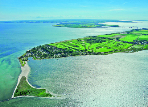 Luchtfoto van Camping en vakantiepark Wulfener Hals met groene grasvelden aan de Oostzee nabij Fehmarn.