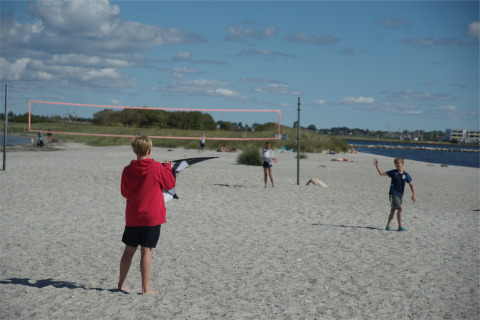 Bambini che giocano sulla spiaggia sabbiosa del Camping en vakantiepark Wulfener Hals, vicino al Mar Baltico.