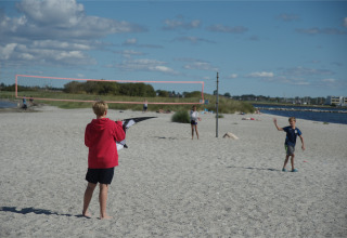 Kinderen spelen op het strand aan de Oostzee bij Camping en vakantiepark Wulfener Hals in de zon.