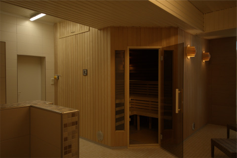 Sauna moderne au Camping en vakantiepark Wulfener Hals avec murs en bois et éclairage doux près de la mer Baltique.