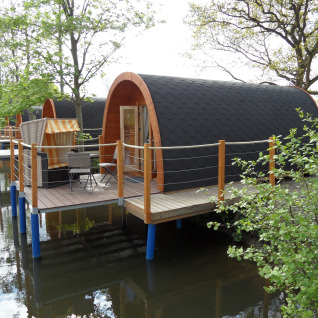 Glamping-Unterkünfte am Wasser im Nord-Ostsee Camp Pods Schleswig-Holstein mit Holzterrassen und Naturblick.