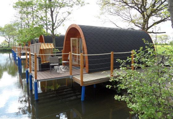 Glamping pods på vandet ved Nord-Ostsee Camp i Slesvig-Holsten med træterrasser og udsigt til naturen.