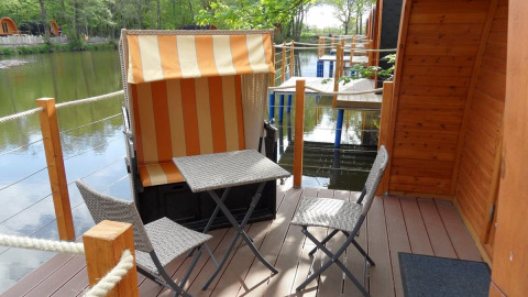 Buitenterras met zitplaatsen aan het meer bij Nord-Ostsee Camp - Pods Sleeswijk-Holstein, glamping accommodatie.