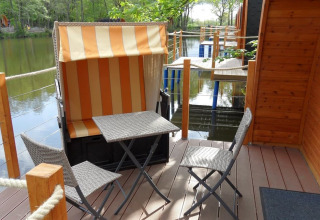 Terrasse mit Sitzgelegenheiten und Blick auf den See im Nord-Ostsee Camp – Pods Schleswig-Holstein, Glamping.