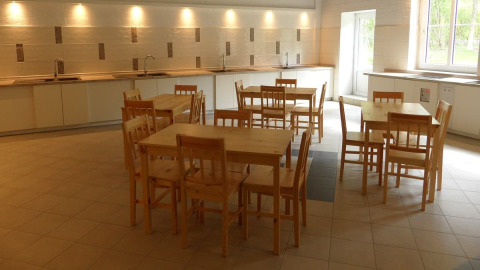 Cuisine commune au Nord-Ostsee Camp - Pods Schleswig-Holstein avec tables et chaises en bois.