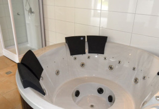 Moderne Whirlpool mit schwarzen Kopfstützen und Duschkabine im Nord-Ostsee Camp - Pods Schleswig-Holstein.