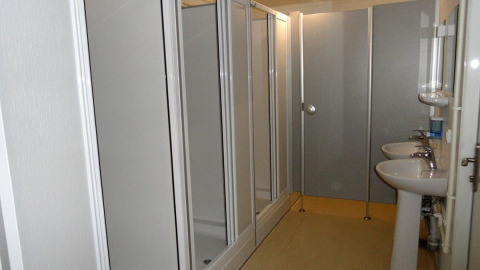 Shared bathroom with showers and sinks at Nord-Ostsee Camp - Pods Schleswig-Holstein glamping site.