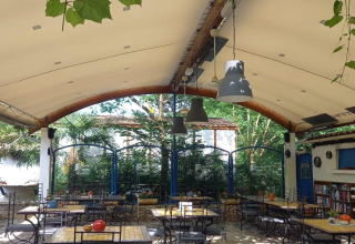 Espace de restauration extérieur couvert avec tables au Camping Les Drouilhedes - Tent Lodges Occitanië.