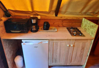 Keukenhoek in een glamping tent bij Camping Les Drouilhedes - Tent Lodges Occitanië met fornuis en koelkast.