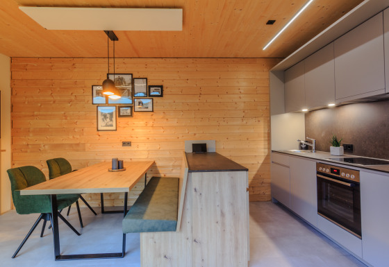 Moderne keuken en eetgedeelte met houten wanden in Wirthshof Resort Comfort chalet aan de Bodensee, glamping.