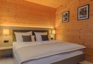 Camera accogliente al Wirthshof Resort Comfort Chalet sul Lago di Costanza con pareti in legno e comfort moderni.