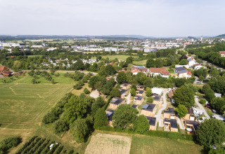 Vue aérienne du glamping Wirthshof Resort près du lac de Constance avec chalets confort et verdure.