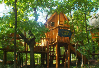 Boomhut glamping accommodatie in Familiepark Sottrum, Nedersaksen, omringd door groene bossen.