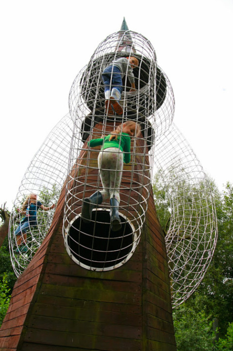 Kinder klettern auf einer Metallrakete im Familiepark Sottrum, einer Glamping-Unterkunft in Niedersachsen.