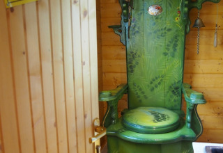 Grüne, thronförmige Toilette in einer Holzhütte im Familiepark Sottrum - Boomhutten Nedersaksen Camping.