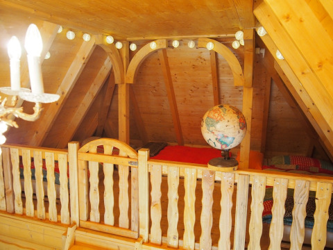 Boomhutinterieur met houten balustrade, globe, lichten en bedden in Familiepark Sottrum, Nedersaksen.
