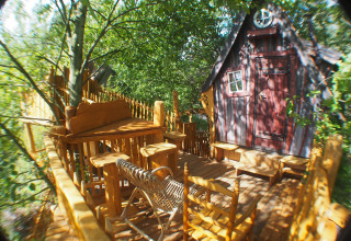 Boomhut glamping accommodatie met houten meubels op terras bij Familiepark Sottrum, Nedersaksen.