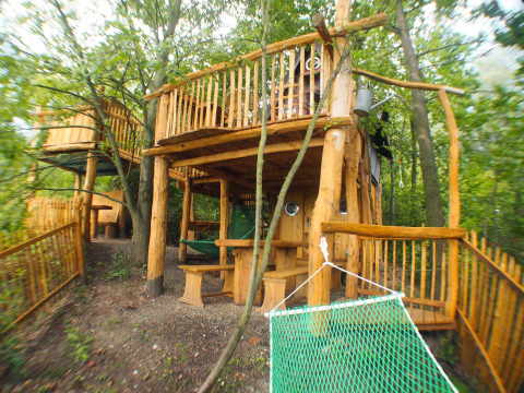 Familiepark Sottrum treehouse glamping in Lower Saxony, spacious wooden treehouse with hammock in forest.