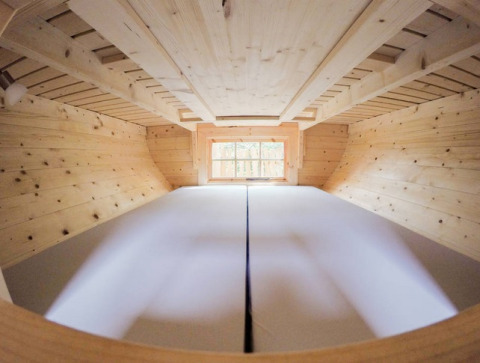 Glamping treehouse at Familiepark Sottrum, Lower Saxony. Loft interior view with bed and natural wood décor.