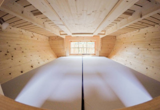 Hébergement en cabane dans les arbres au Familiepark Sottrum, Basse-Saxe. Vue loft et lit en bois.