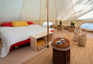 Interno della tenda glamping di Azienda Agricola Il Granello in Italia, con letto matrimoniale e arredi eleganti.