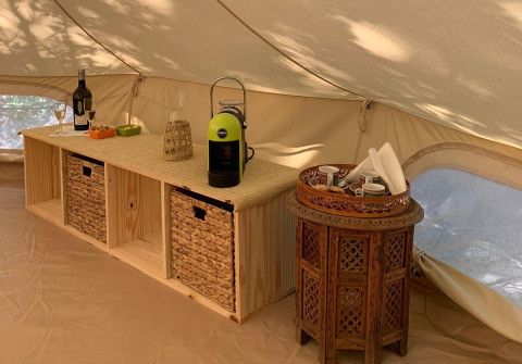 Interior de tienda glamping en Azienda Agricola Il Granello con café, vino y snacks en Italia.