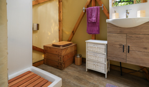 Baño glamping con inodoro de madera, ducha, lavabo moderno y almacenamiento en Il Granello, Italia.