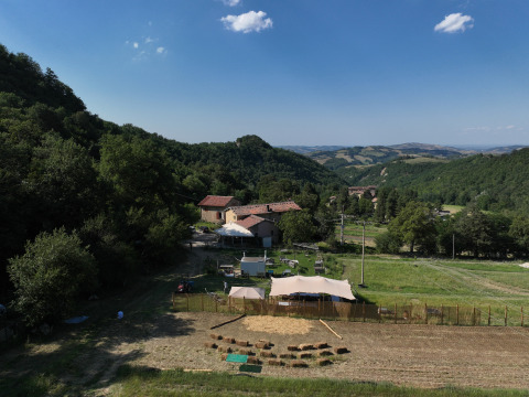 Tentes de glamping à Azienda Agricola Il Granello en Italie, entourées de collines verdoyantes et de ferme