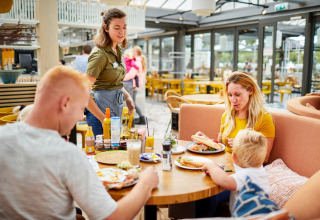 Familie nyder morgenmad i Restaurant LoungeLodge på Recreatiepark TerSpegelt, Glamping i Noord-Brabant.