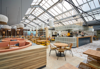 Lichte, moderne lounge bij Recreatiepark TerSpegelt - LoungeLodge Glamping Noord-Brabant met rotan meubels.