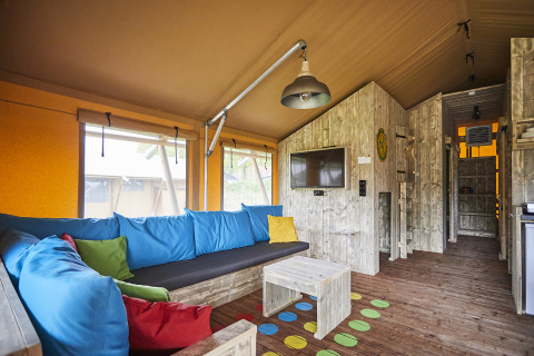 Intérieur du LoungeLodge Glamping au Recreatiepark TerSpegelt, décor chaleureux avec coussins colorés.