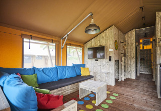 Interieur van LoungeLodge Glamping bij Recreatiepark TerSpegelt, gezellige zithoek met kleurrijke kussens.