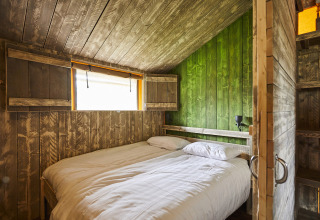 Dormitorio en LoungeLodge Glamping en Recreatiepark TerSpegelt, Noord-Brabant, con decoración rústica de madera.