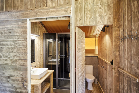 Moderne houten badkamer met wastafel, douche en toilet in LoungeLodge Glamping Noord-Brabant, Nederland.