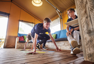 Familie entspannt sich und spielt gemeinsam in der LoungeLodge Glamping im Recreatiepark TerSpegelt, Noord-Brabant.