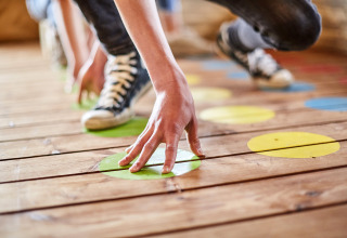Niños juegan Twister en LoungeLodge Glamping de Recreatiepark TerSpegelt en Noord-Brabant, Países Bajos.