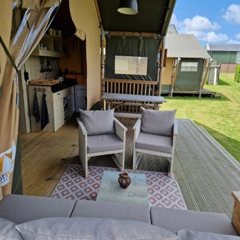 Safari-Zelt mit moderner Einrichtung und gemütlichem Wohnbereich bei Glamping Heemskerkerduin, Niederlande.