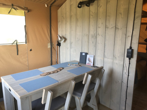 Interieur van houten tafel met stoelen bij Glamping Heemskerkerduin, Safaritenten, Noord-Holland.