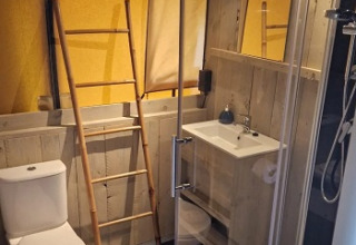 Moderne badeværelse med træelementer i Glamping Heemskerkerduin Safaritenten, Holland.