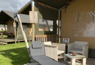 Glamping Heemskerkerduin - Safaritenten Noord-Holland con terraza de madera, sillas lounge y área exterior.