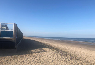 Vista sulla spiaggia del Glamping Heemskerkerduin Safaritenten Noord-Holland con cielo limpido e sabbia.