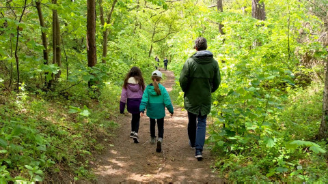 Familia paseando por un sendero verde junto a Glamping Heemskerkerduin, Safaritenten, Noord-Holland.