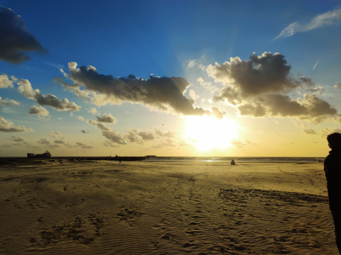 Zonsondergang aan het strand bij Glamping Heemskerkerduin - Safaritenten Noord-Holland met een bewolkte lucht.