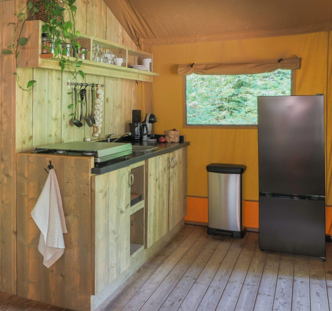 Gemütliche Campingküche bei Buitenplaats Beekhuizen - Glamping Veluwe mit Holzfronten und modernem Kühlschrank.